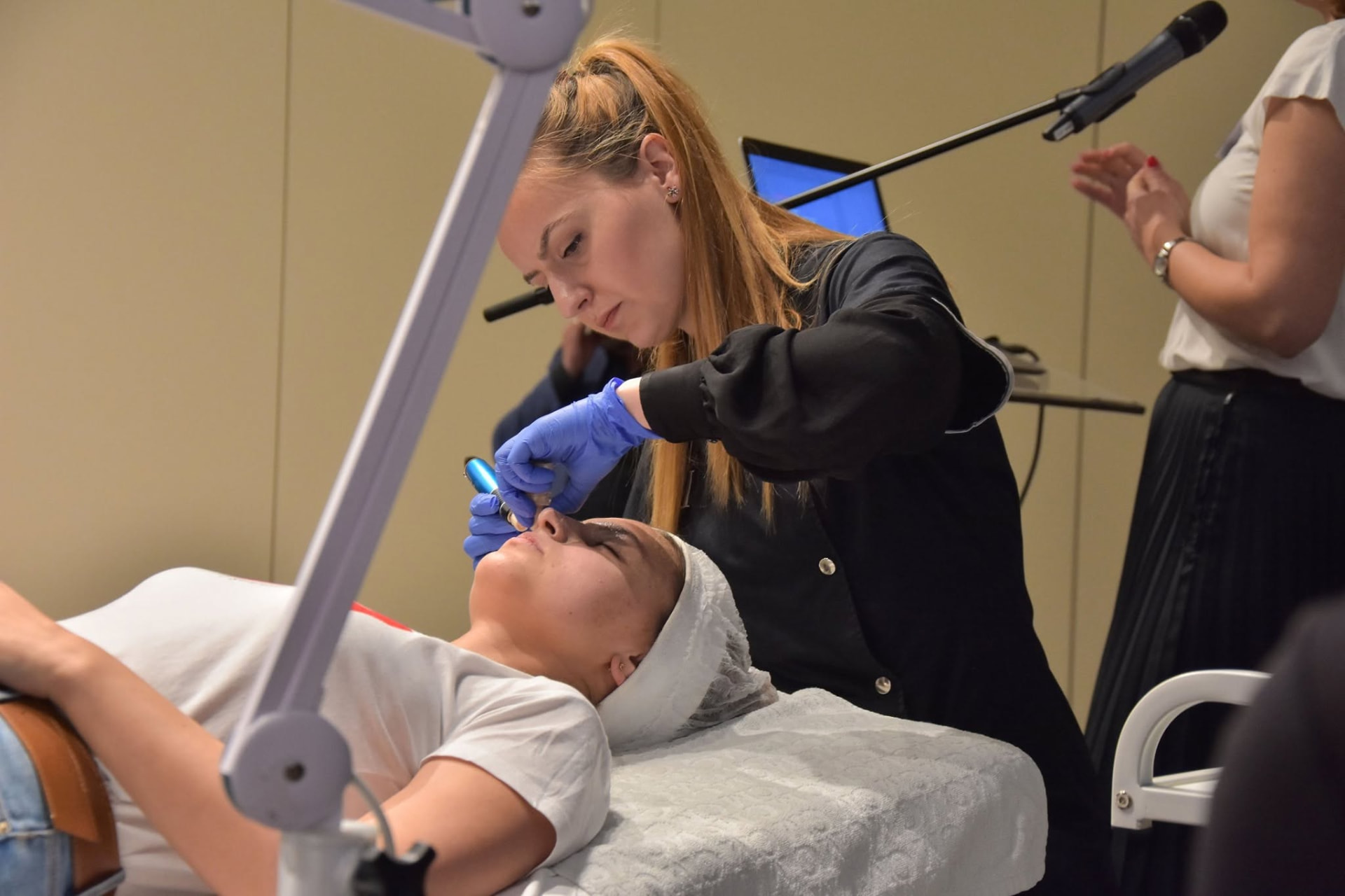 Esthetician performing a treatment during a live demonstration